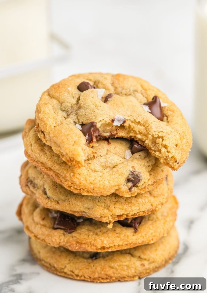 Chewy Sea Salt Chocolate Chip Cookies Recipe 2 Stack of chewy chocolate chip cookies with bite out of top cookie