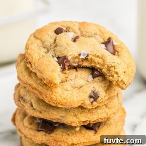Stack of chewy chocolate chip cookies with bite out of top cookie