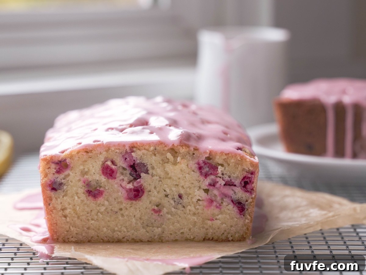 Cranberry almond loaf cake sliced to show cranberries inside