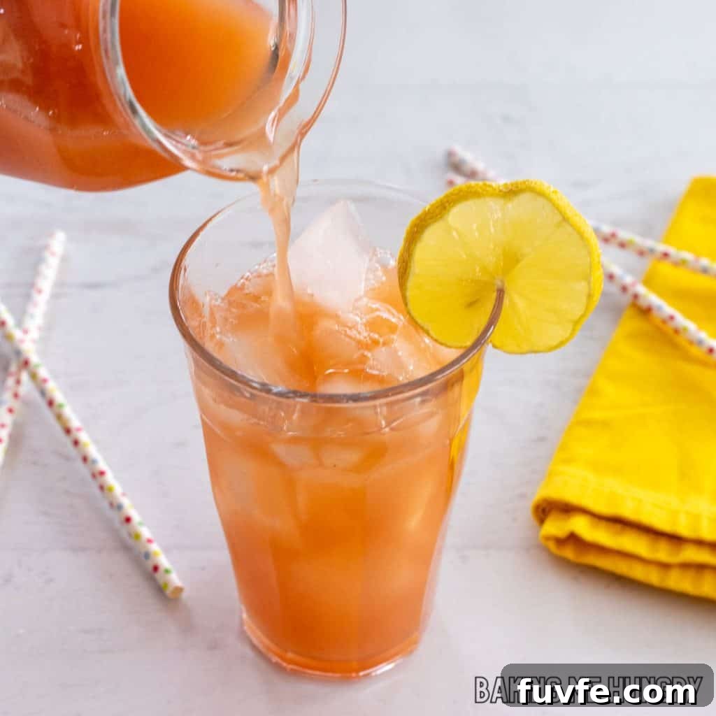 iced guava white tea lemonade recipe being poured into a glass of ice