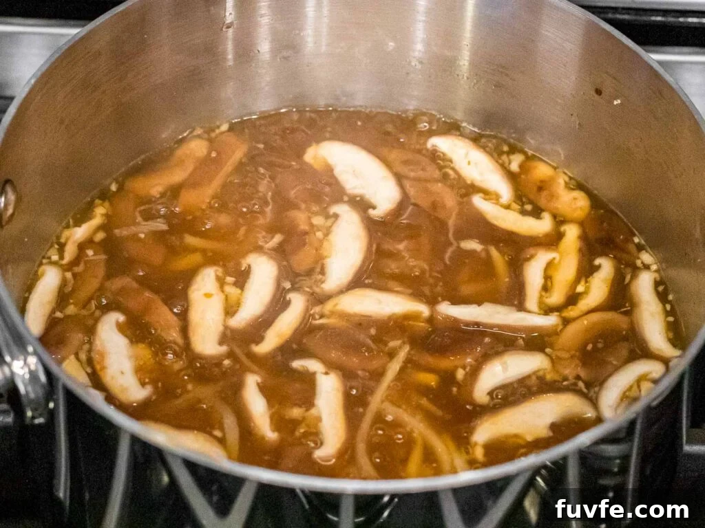 hot and sour soup in a pot with shiitake mushrooms