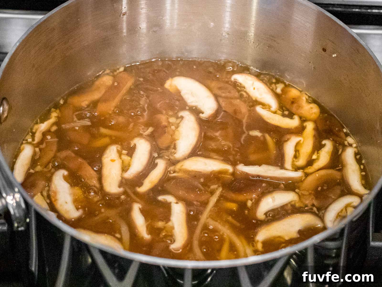 hot and sour soup in a pot with shiitake mushrooms