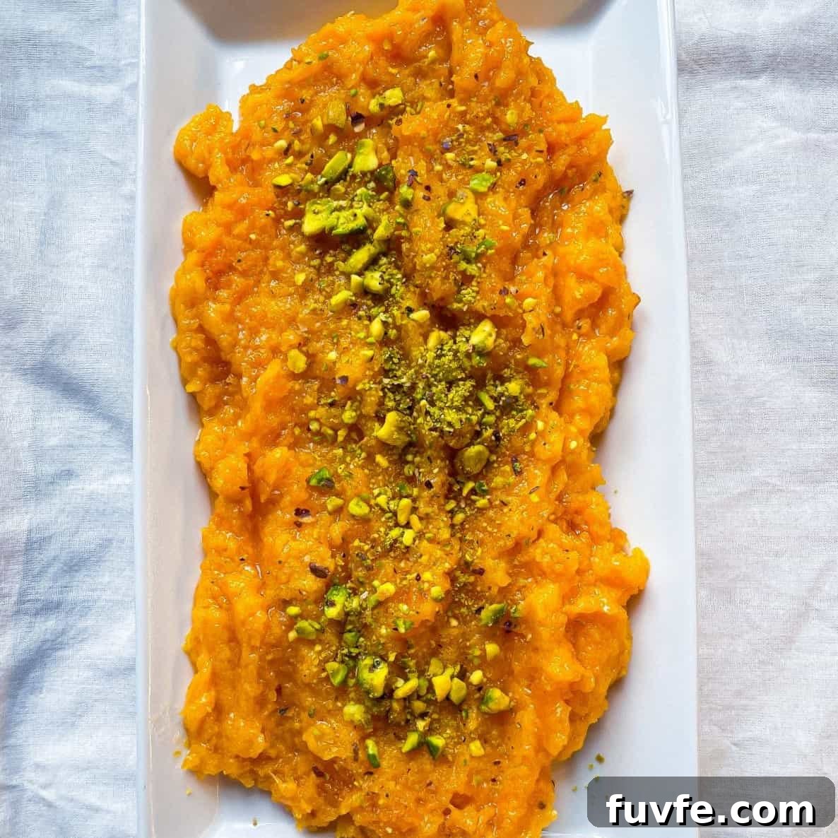 A plate of pumpkin halwa garnished with chopped pistachio