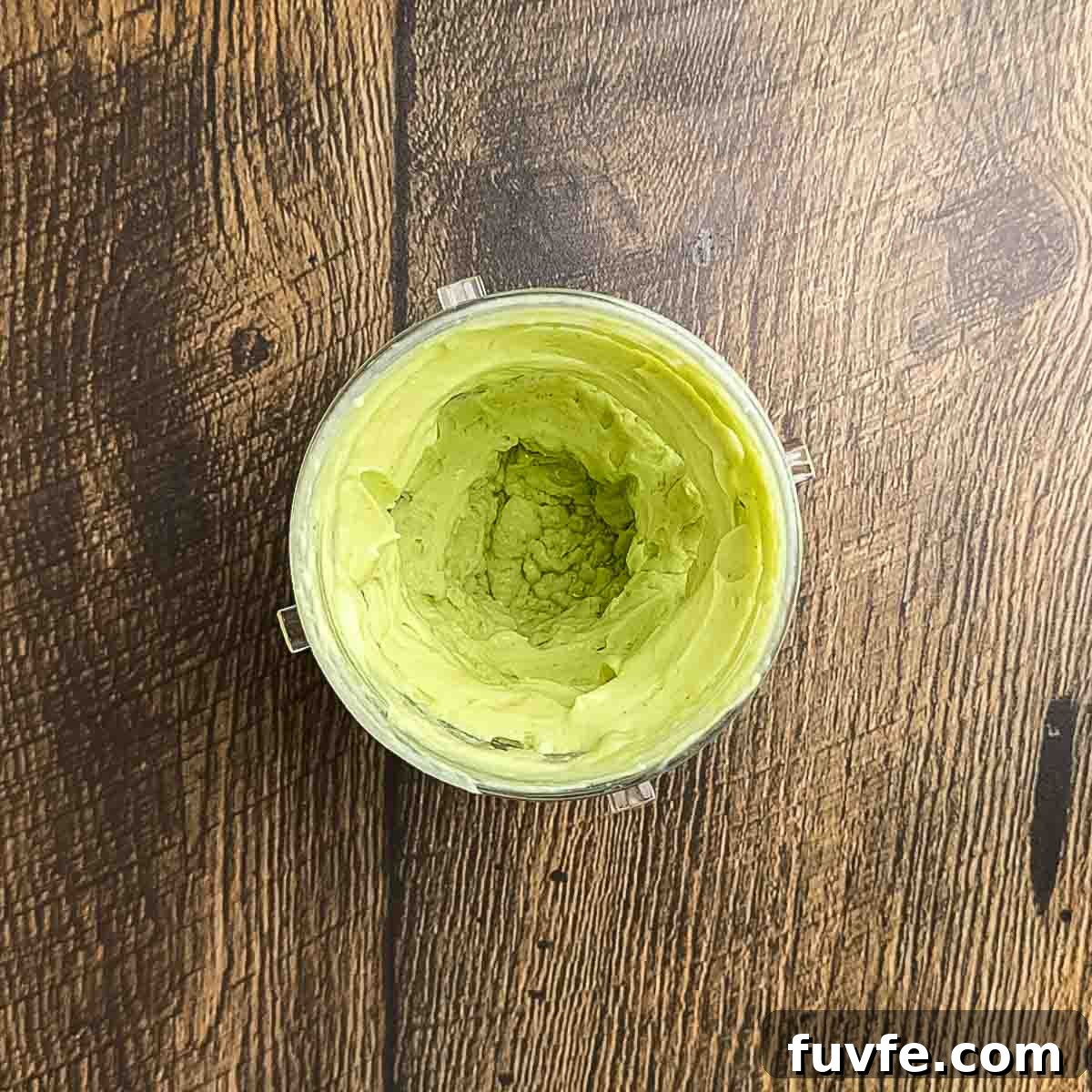 The ingredients for the avocado lime crema blended in a blender.