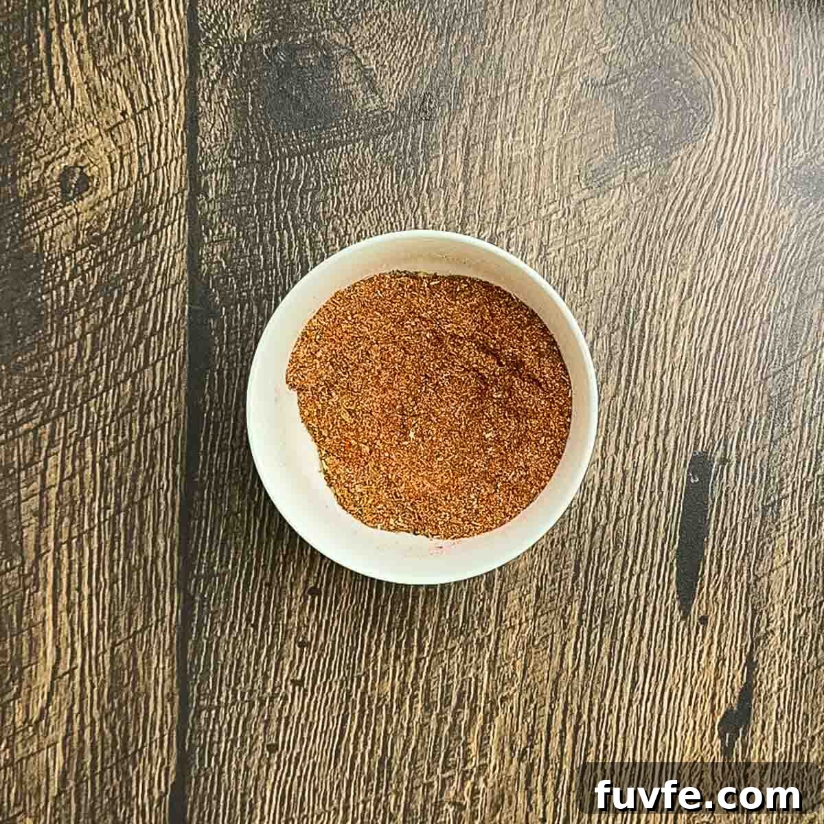 The ingredients for the blackened seasoning combined in a small white bowl.
