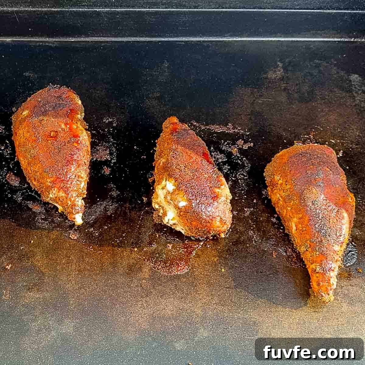 Cooked blackened chicken breasts on the grill.