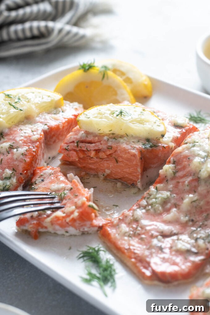 Pan-Seared Garlic Butter Salmon with Lemon 7 Garlic butter baked salmon with fork cutting into it.