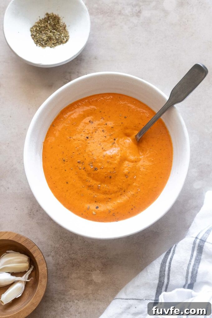 Homemade Roasted Red Pepper Sauce Recipe 6 Creamy roasted red pepper sauce in a bowl with a spoon.