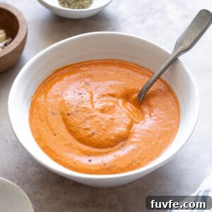 Homemade Roasted Red Pepper Sauce Recipe 7 Roasted red pepper sauce in a bowl with a spoon digging in.