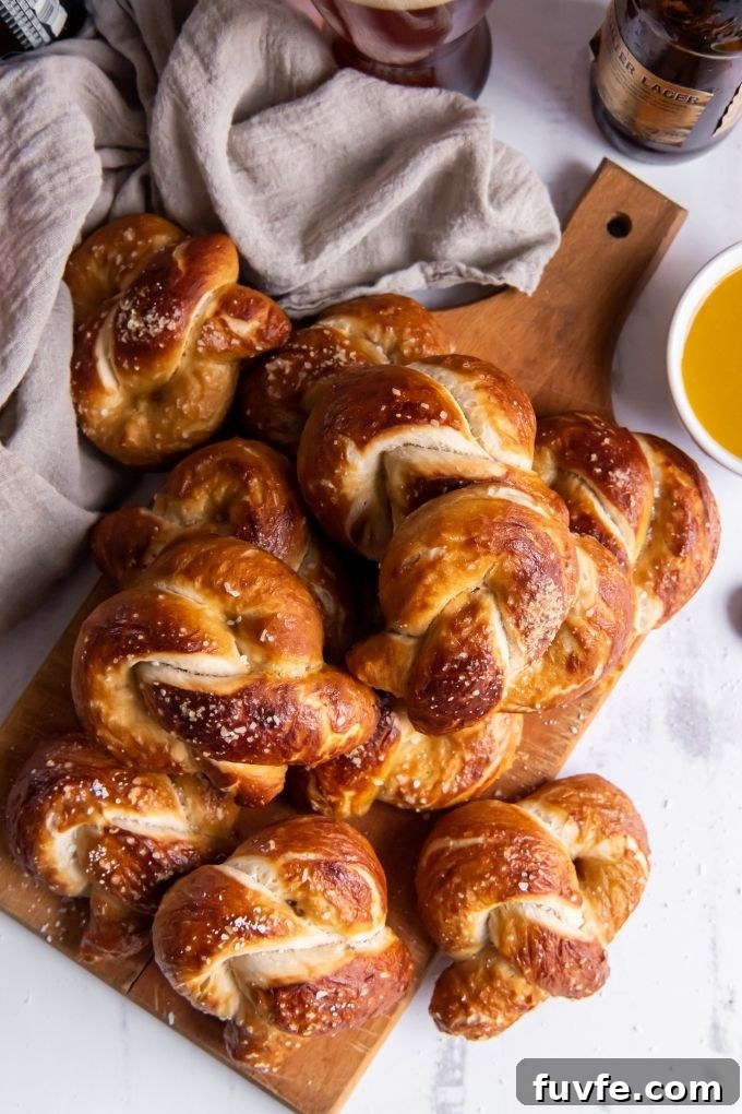Soft Pretzel Recipe with Maple Mustard Dipping Sauce 3 Soft pretzels piles on a cutting board with mustard sauce