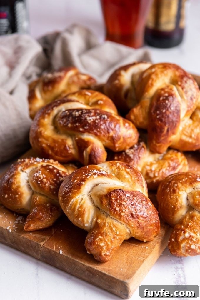 Homemade soft pretzels piled on a wooden cutting board
