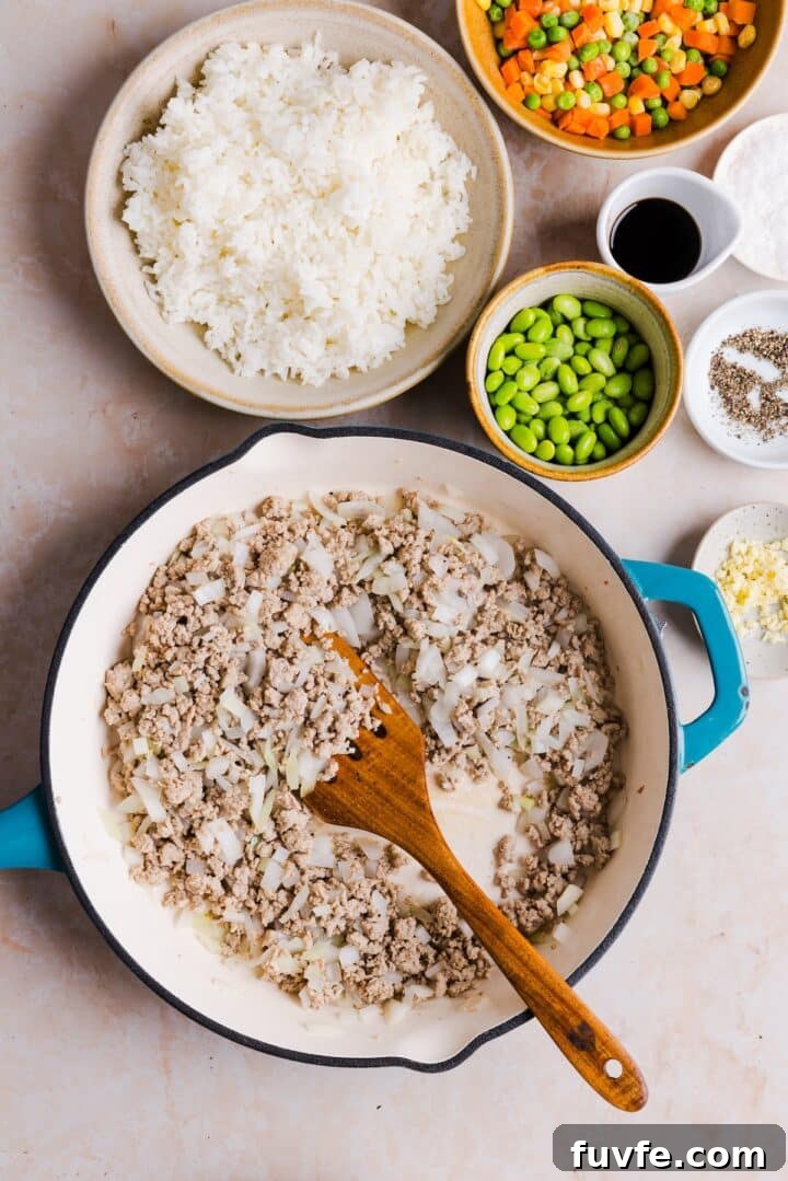 Savory Ground Turkey Fried Rice Recipe — Quick Weeknight Meal 7 Diced onions and crumbled ground turkey cooked in a large pan