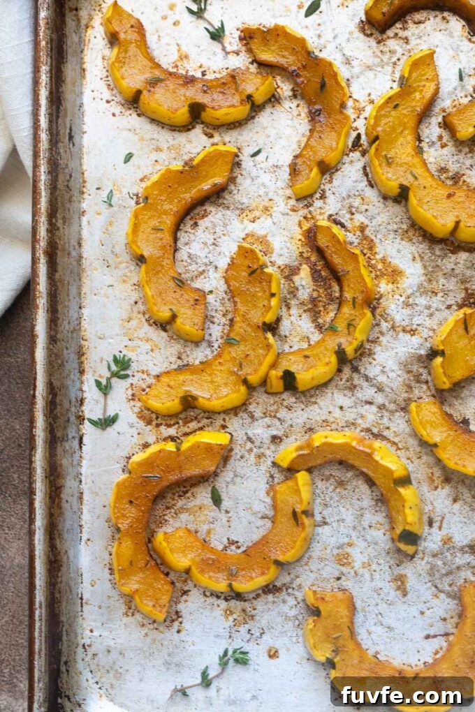 Roasted Delicata Squash with Maple Glaze 6 Roasted delicata squash on a sheet pan with thyme sprigs.