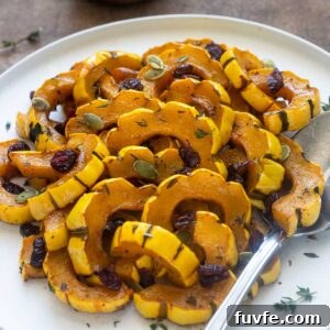 Roasted Delicata Squash with Maple Glaze 8 Maple roasted delicata squash on a plate with thyme leaves.