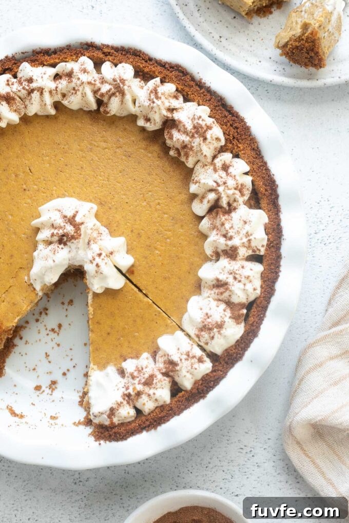 Creamy Pumpkin Cheesecake Pie Recipe 3 Pumpkin pie cheesecake with whipped cream piped on top.