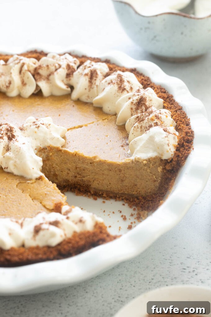 Pumpkin pie cheesecake in pie dish with a slice missing.