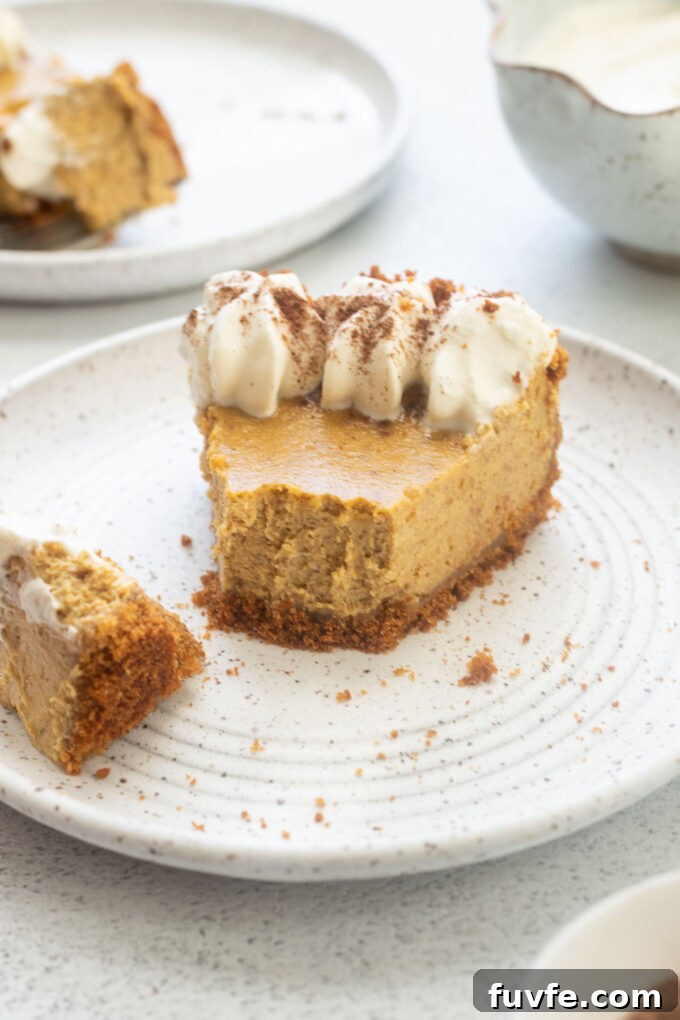 Creamy Pumpkin Cheesecake Pie Recipe 8 Pumpkin cheesecake pie on a plate with a bite taken out of it.