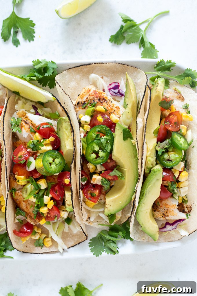 Cod fish tacos topped with salsa, avocado and jalapeno
