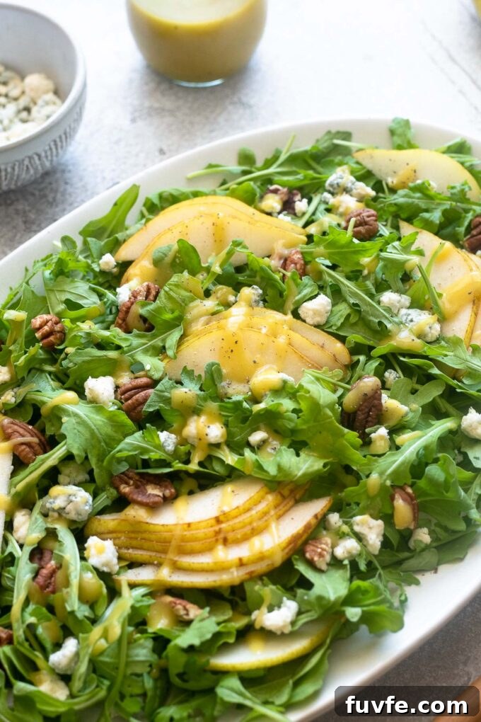 Arugula and Pear Salad with Honey-Balsamic Dressing 3 Arugula and pear salad on a platter with champagne vinaigrette.
