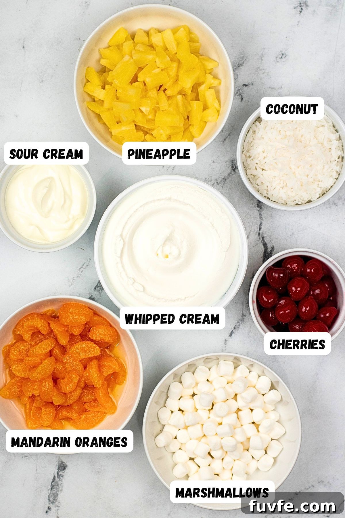 Ingredients measured into small bowl, such as fruit and whipped cream, then shown with labels for each ingredient. 
