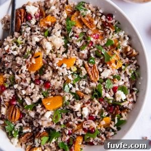 Wild Rice Salad with Orange and Pomegranate Recipe 8 Wild rice salad in a white bowl with a serving spoon