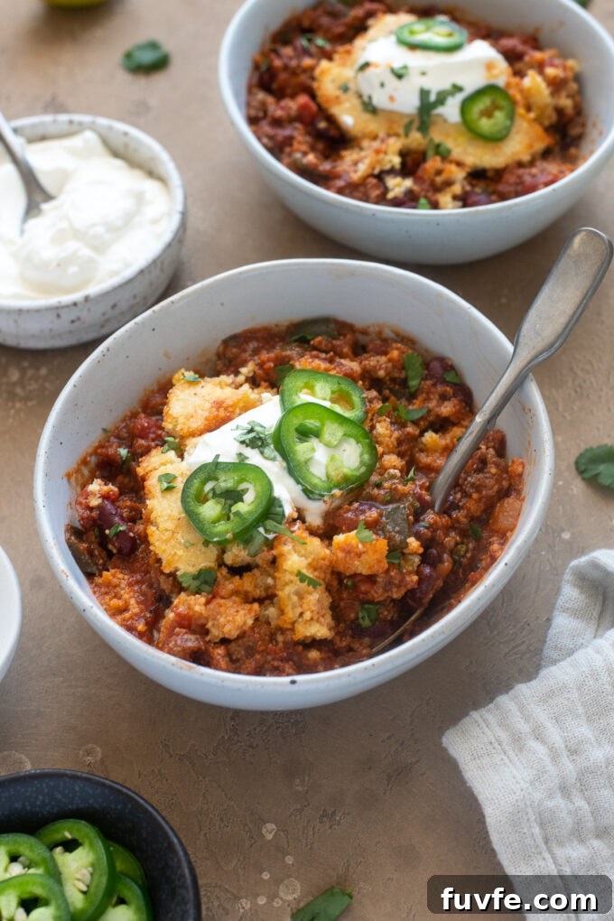 Cheesy Chili Cornbread Casserole Recipe 9 Easy cornbread chili casserole in a bowl with sour cream and jalapenos.