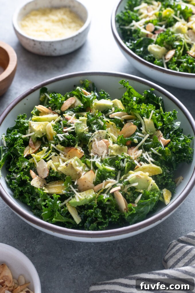 Kale Salad with Brussels Sprouts in a bowl with avocado and almonds.