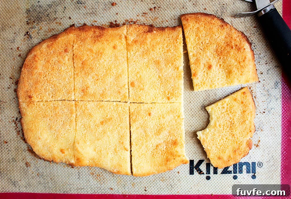 keto garlic flatbread finished and baked piece fully sliced with one piece moved aside