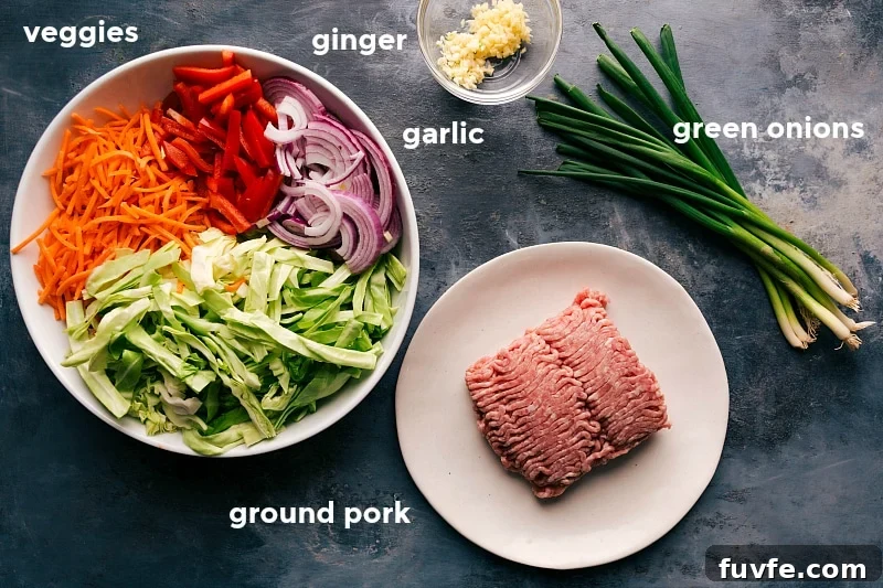 Collection of ingredients for the egg roll in a bowl recipe, including ground meat, vegetables, and seasonings.