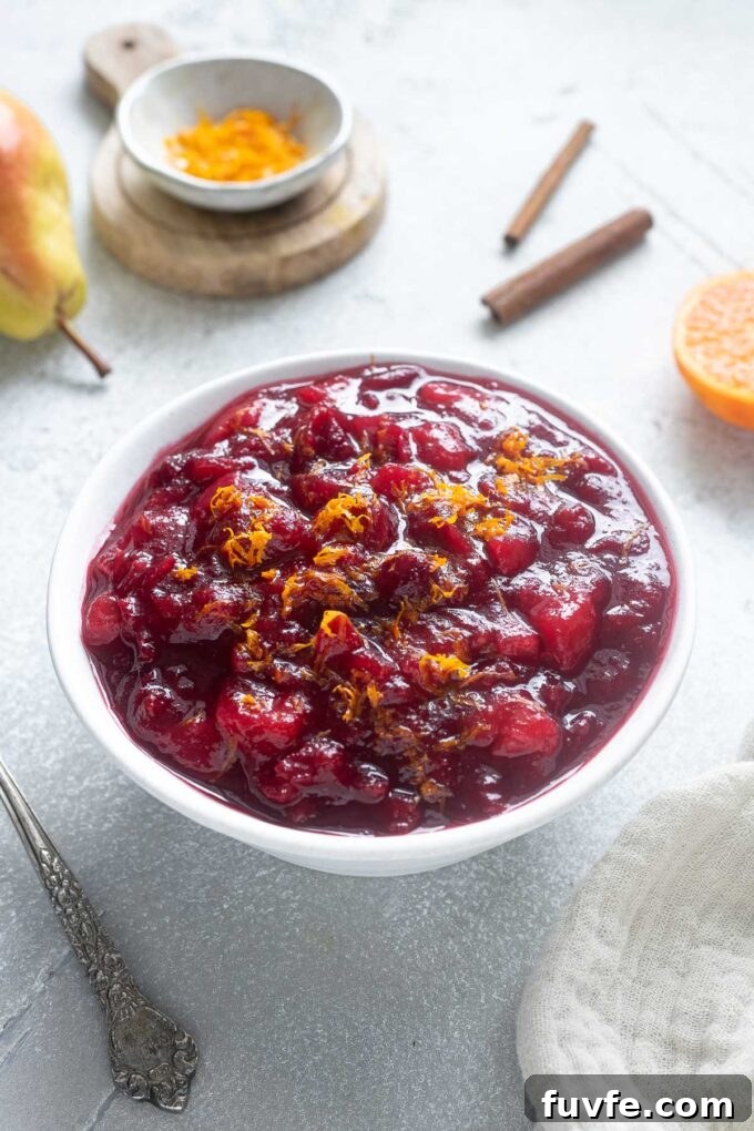 Cranberry sauce with port in a bowl with orange zest on top.
