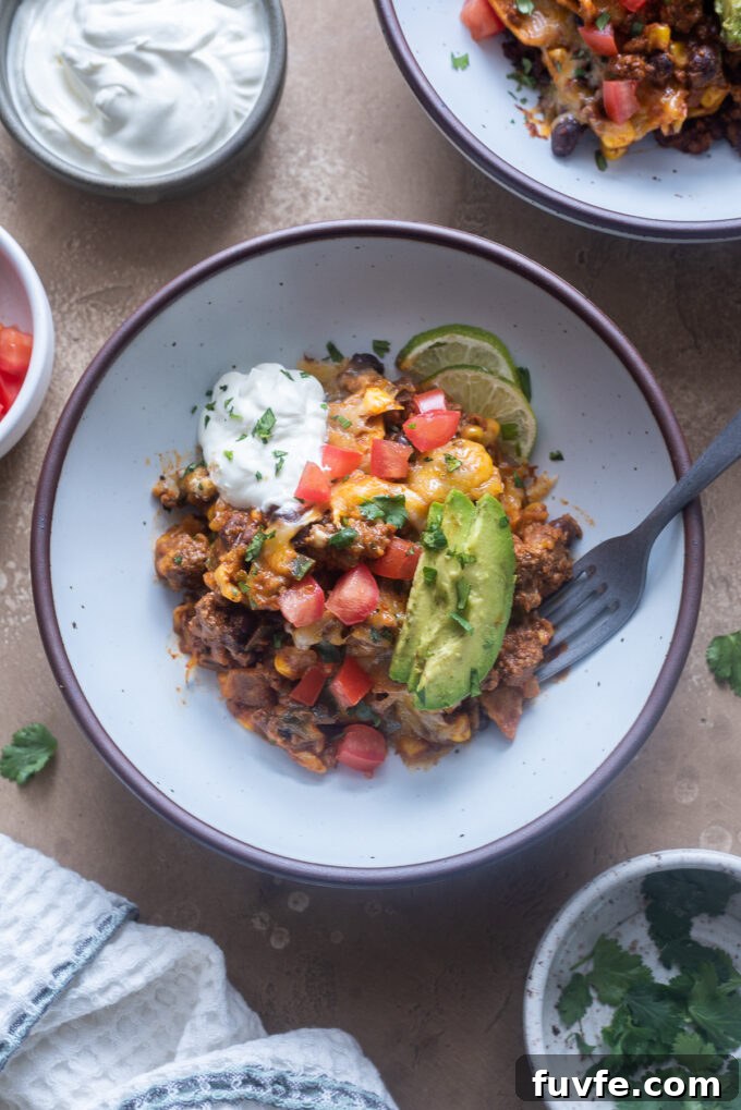 Cheesy Ground Beef Enchilada Casserole Recipe 8 Serving of ground beef enchiladas skillet in a bowl with toppings.