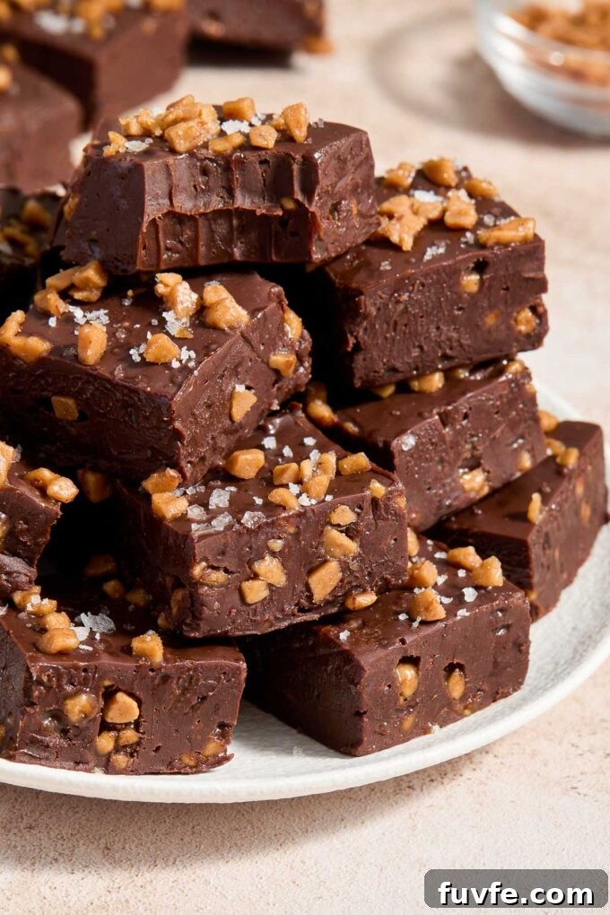 Squares of dark chocolate fudge piled on a plate.