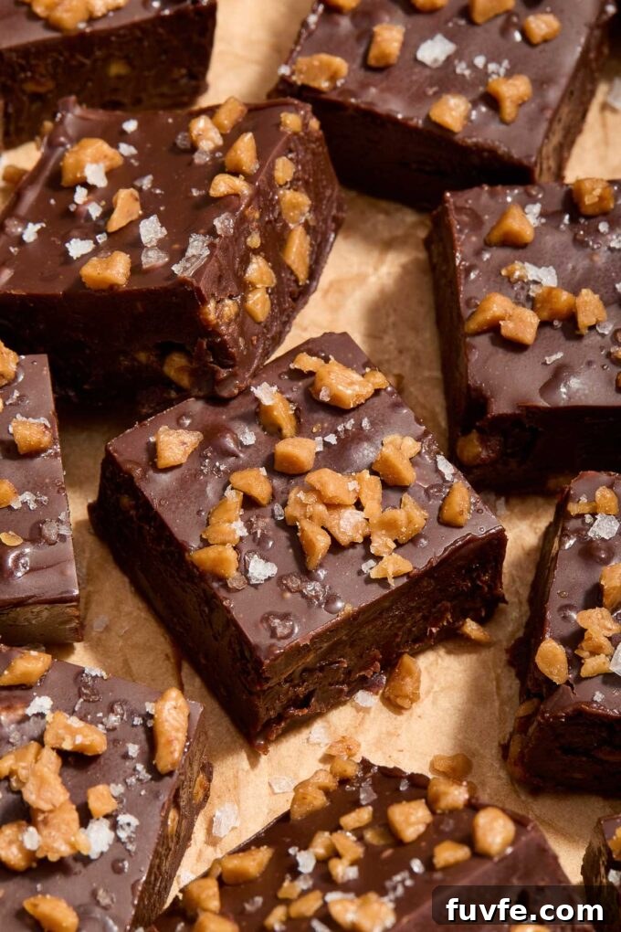 Dark chocolate toffee fudge cut into squares on parchment paper.