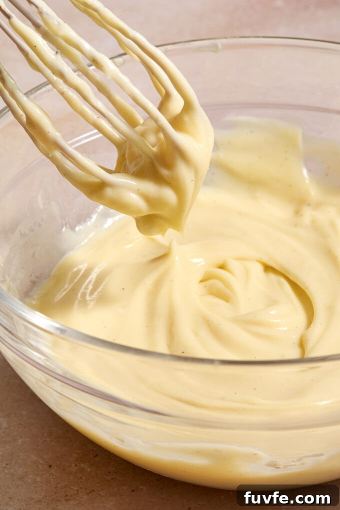 Silky Pastry Cream (Crème Pâtissière) Recipe 3 Bowl of creme patissiere with a whisk.