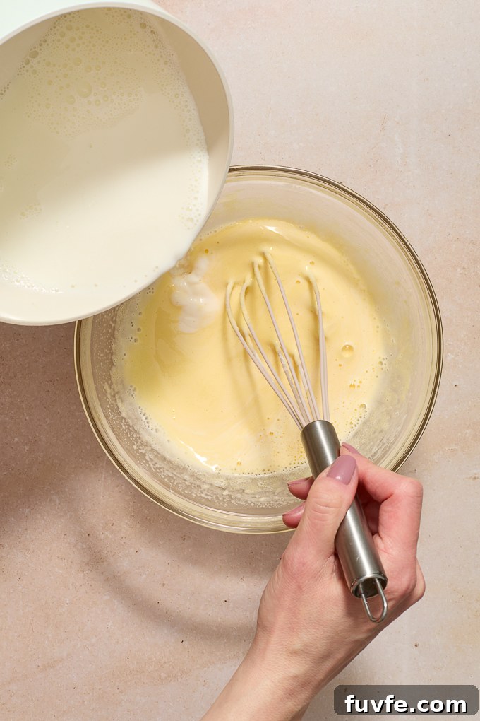 Silky Pastry Cream (Crème Pâtissière) Recipe 7 Milk pouring slowly into pastry cream.