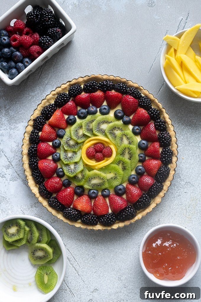 French fruit tart decorated with fresh fruit design.