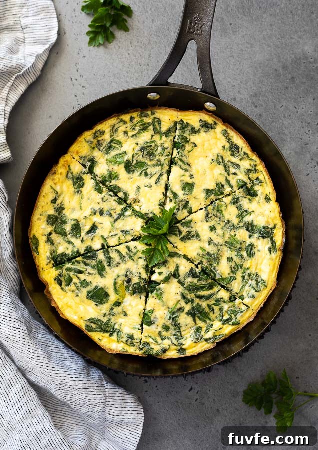 Spinach frittata in a skillet cut into slices
