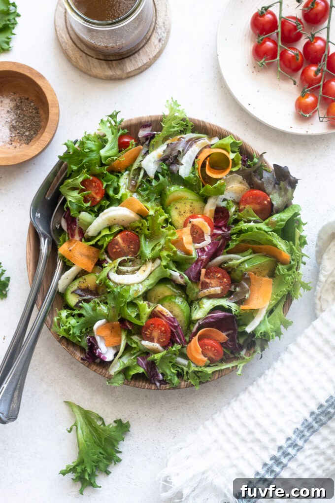 Insalata Mista in serving bowl with wooden servers.