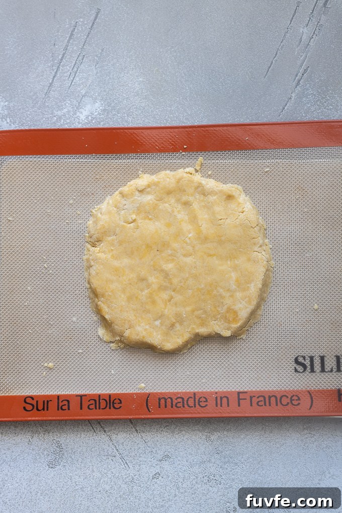 Sweet tart dough shaped in a disc on a Silpat mat.