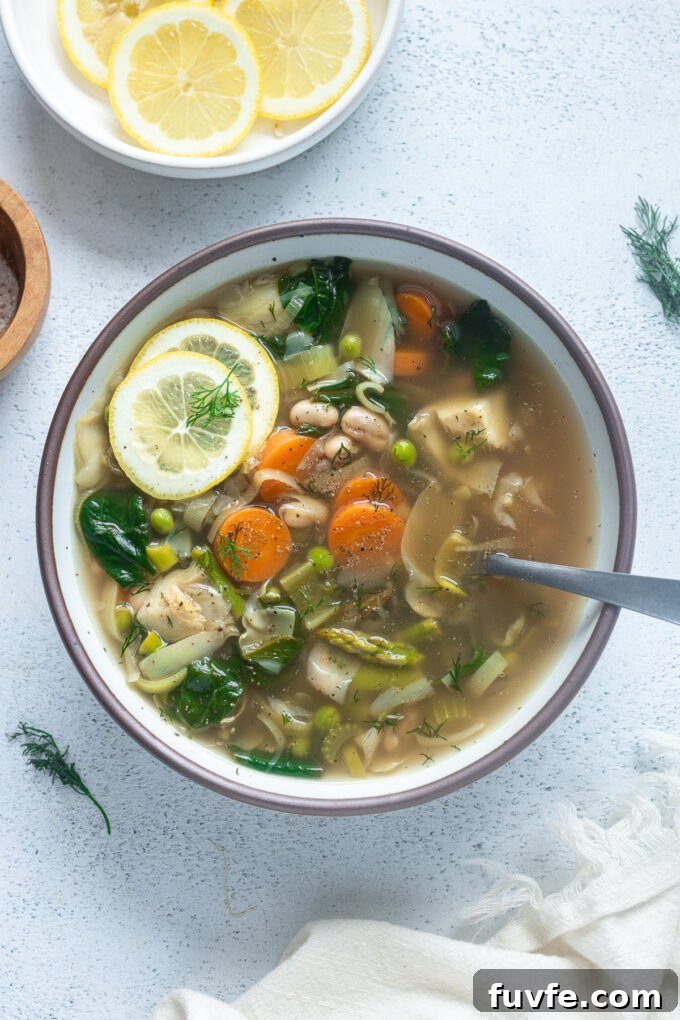 Bright Spring Vegetable Soup Recipe with Fresh Herbs 10 Spring Vegetable Soup in a bowl with a spoon buried in it.