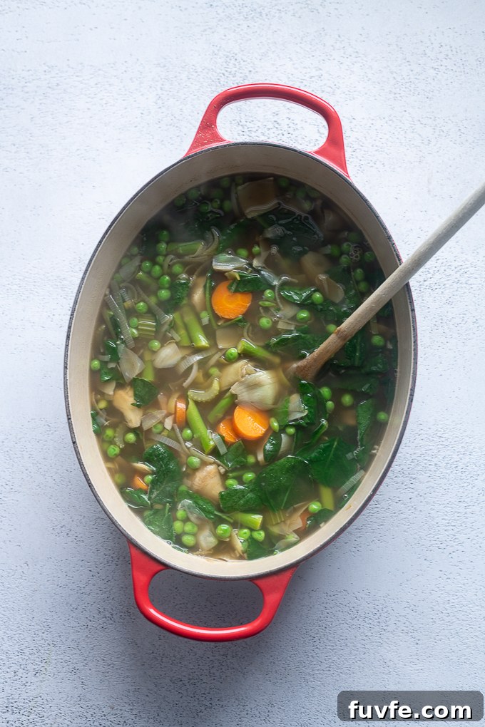 Bright Spring Vegetable Soup Recipe with Fresh Herbs 7 Spring vegetable soup with peas and spinach added.