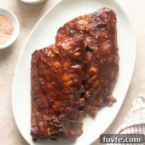 Fall-Off-the-Bone Slow-Cooker Baby Back Ribs 12 Slow cooker baby back ribs on a platter smothered in barbecue sauce.