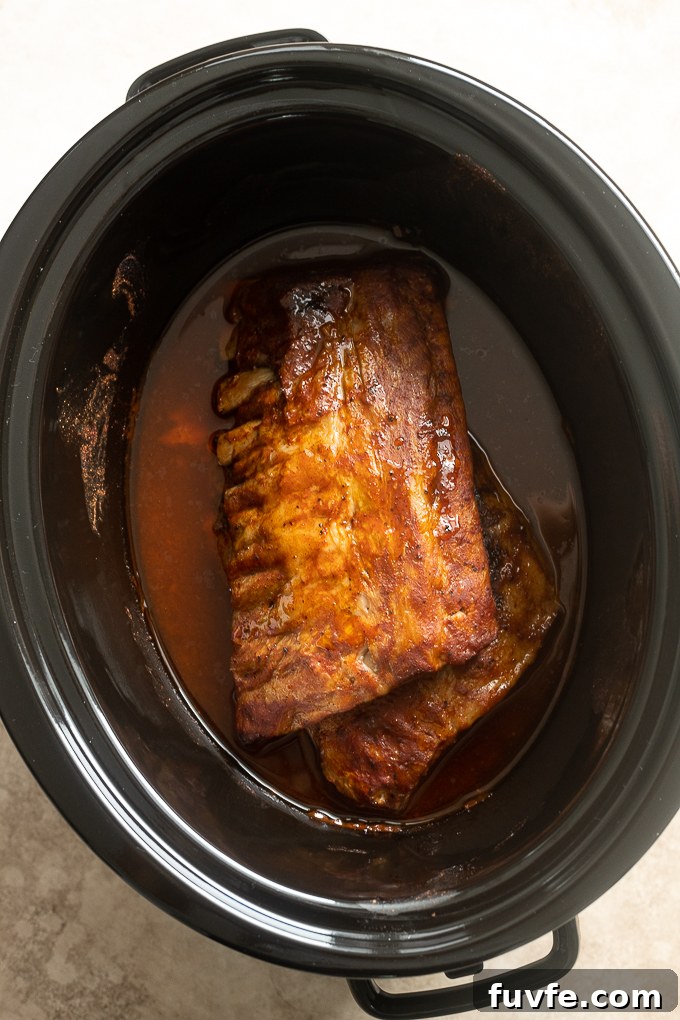 Fall-Off-the-Bone Slow-Cooker Baby Back Ribs 7 Cooked bbq baby back ribs in slow cooker.