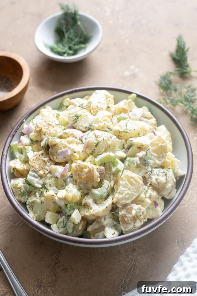 Potato salad with dill and pickles in a serving bowl.