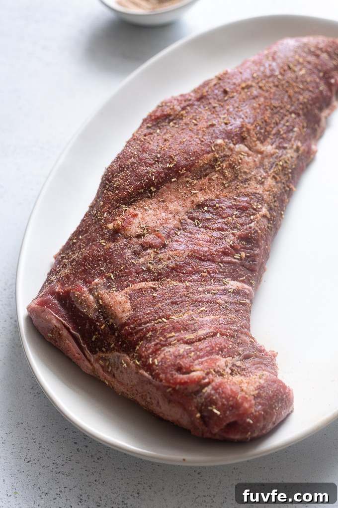 Seasoned beef tri tip roast on a platter.