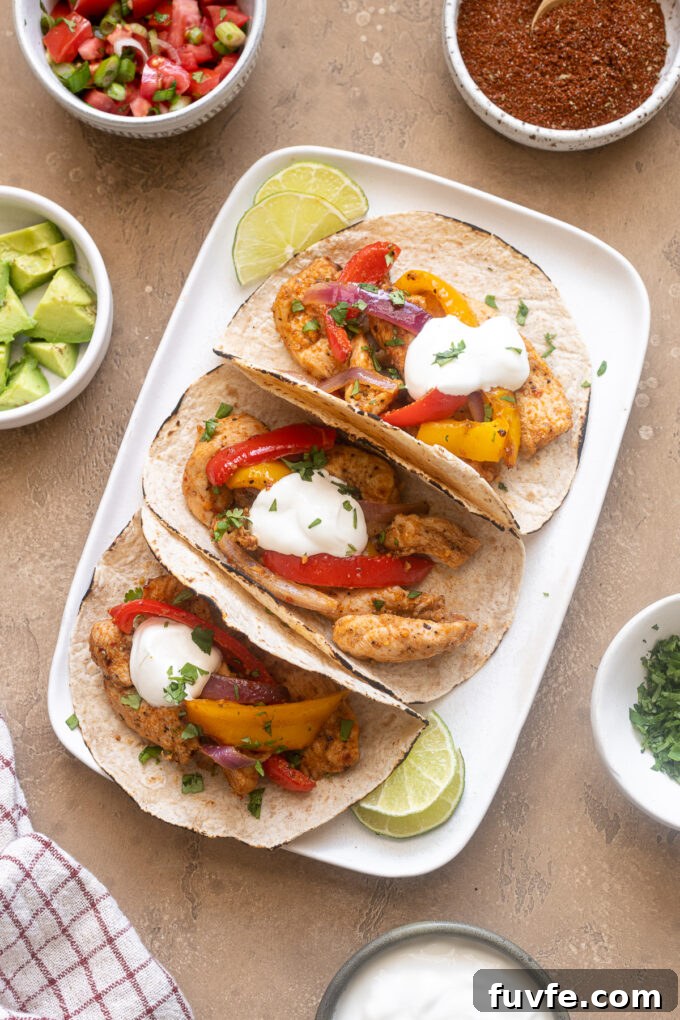 Air Fryer Chicken Fajitas Recipe: 20-Minute Dinner 2 Air fryer chicken fajitas on a platter with toppings.