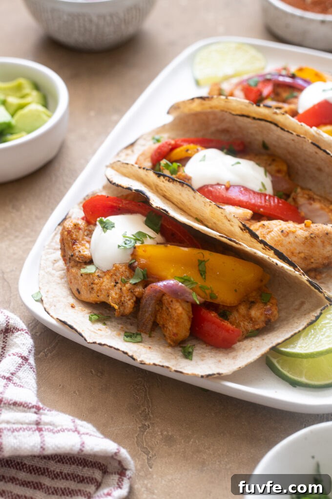 Air fryer fajitas with chicken on a platter with toppings.