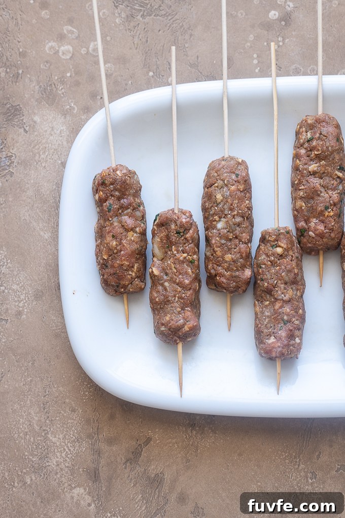 Lamb kofta formed into oblong logs and skewered.