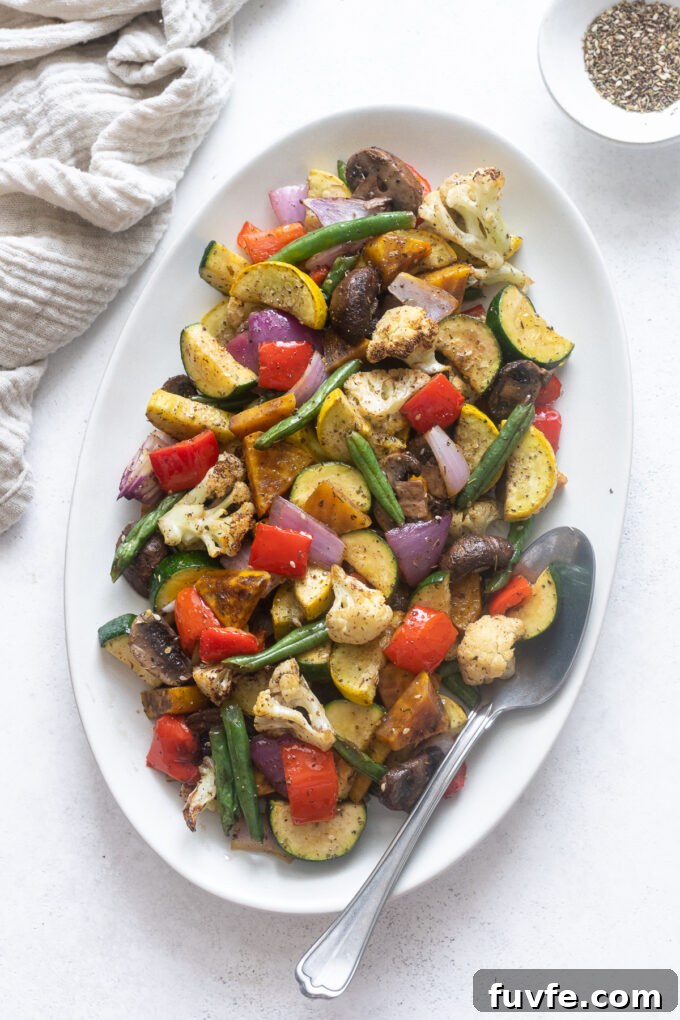 Air fryer roasted vegetables on a platter with a serving spoon.