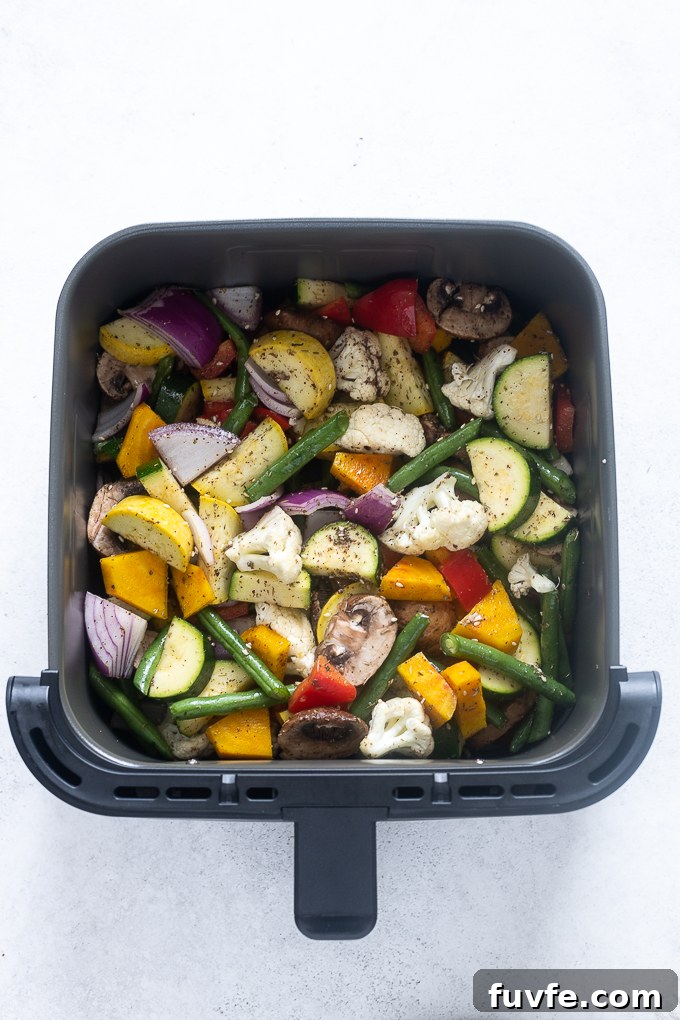 Vegetables in air fryer before cooking.